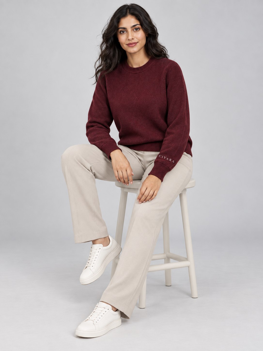 The Sceptre Crew worn seated, with cream wide-leg trousers.